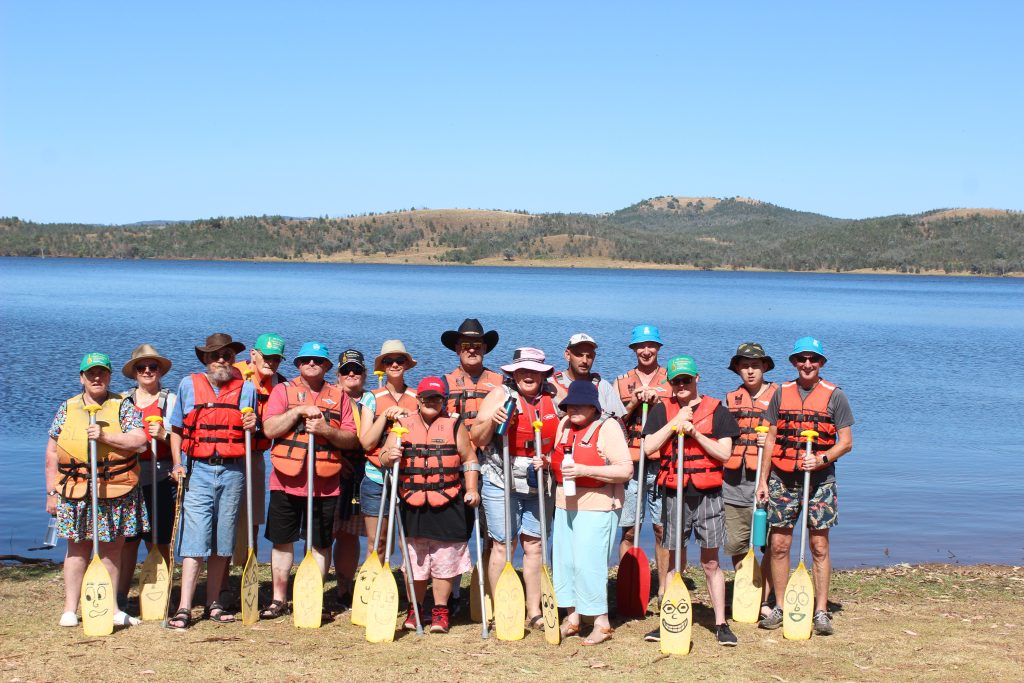 Leisure Options travel group on the beach holding paddles getting ready to go on the water